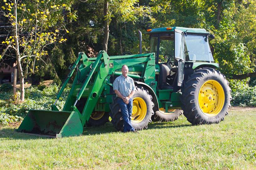 Dave Heilman posing in front of a tractor on North Campus
