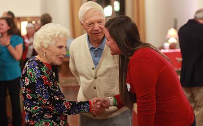 Bryn Athyn College students shakes hand of elderly lady