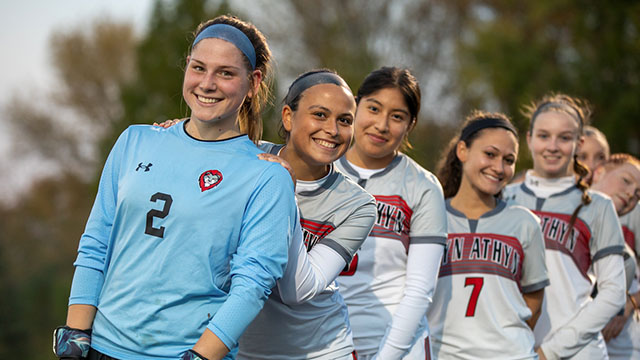 Women's soccer team in a line smiling