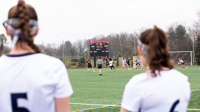 Women's field hockey players look over the General Nelson Field