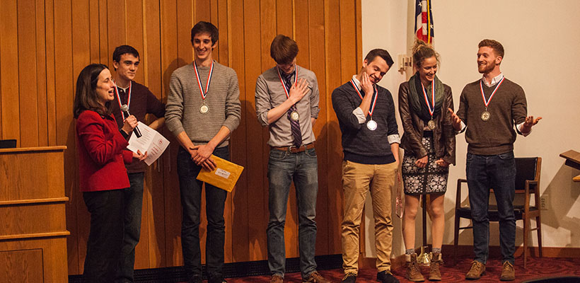 Bryn Athyn College students on stage receiving medals for winning a contest