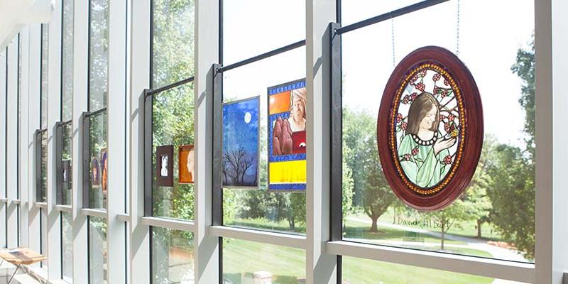 Student stained glass work lines a window of the Swedenborg Library