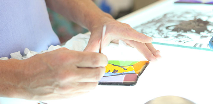 Student works on an illumnated table with a stained glass panel at Bryn Athyn College