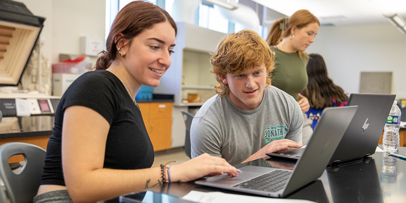 Students smiling at a computer