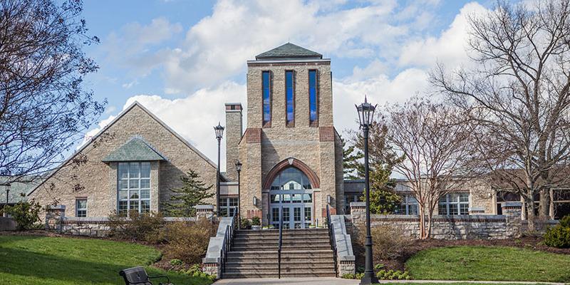 Bryn Athyn College Brickman Center, as seen from the path leading towards the terrace, showcasing the blue-glassed tower