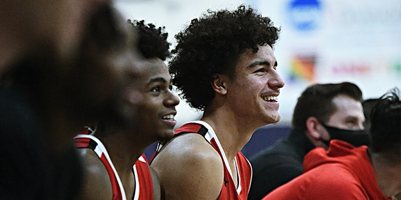 Men's basketball athletes smile during a game