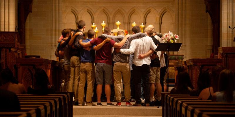 Students huddle together at the alter during a blessing service