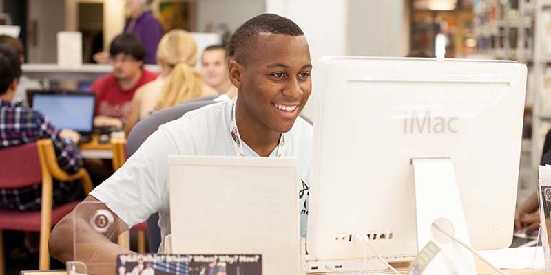 Student happily works at a computer